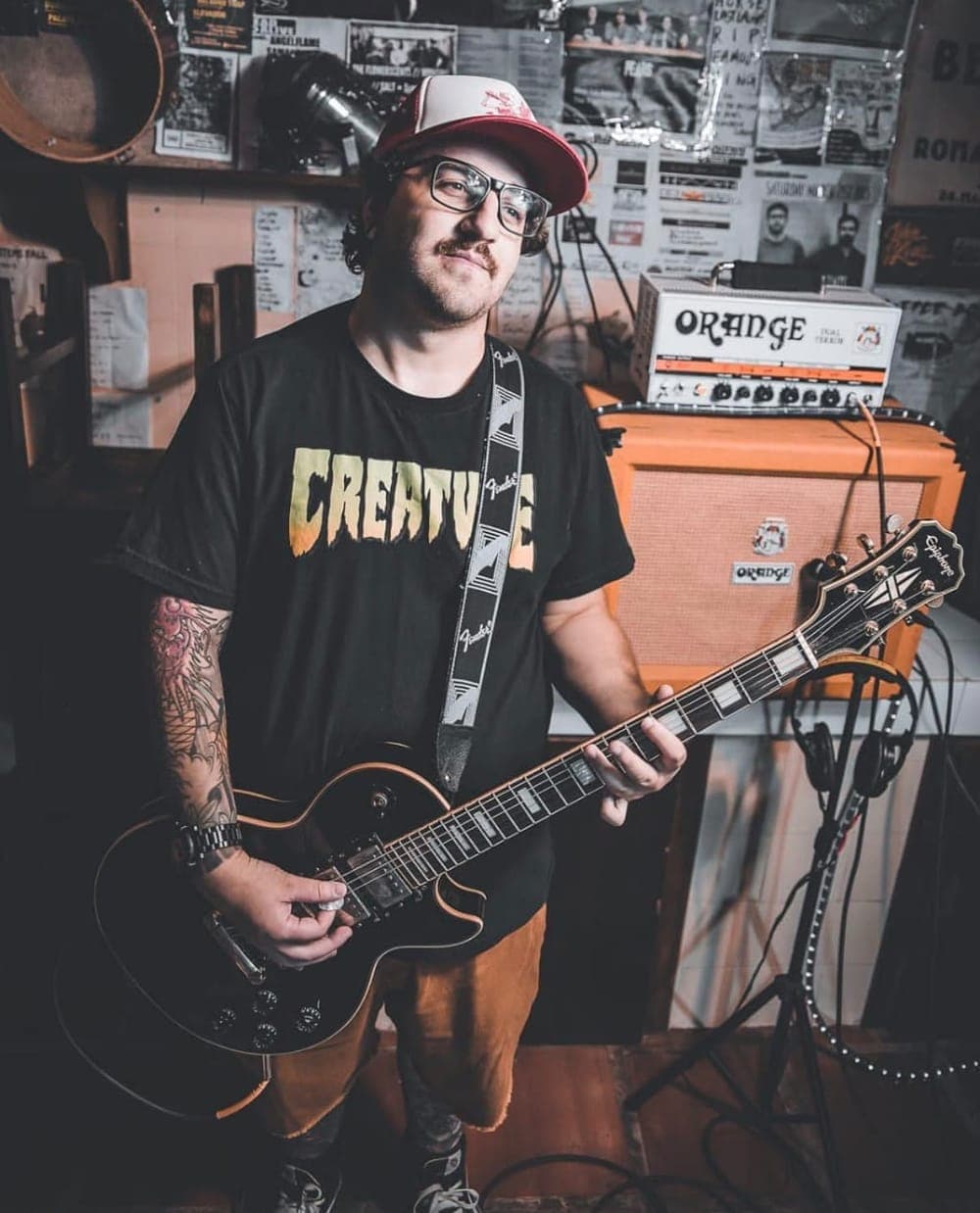 Mateus Rosa com a guitarra em uma sala de ensaio