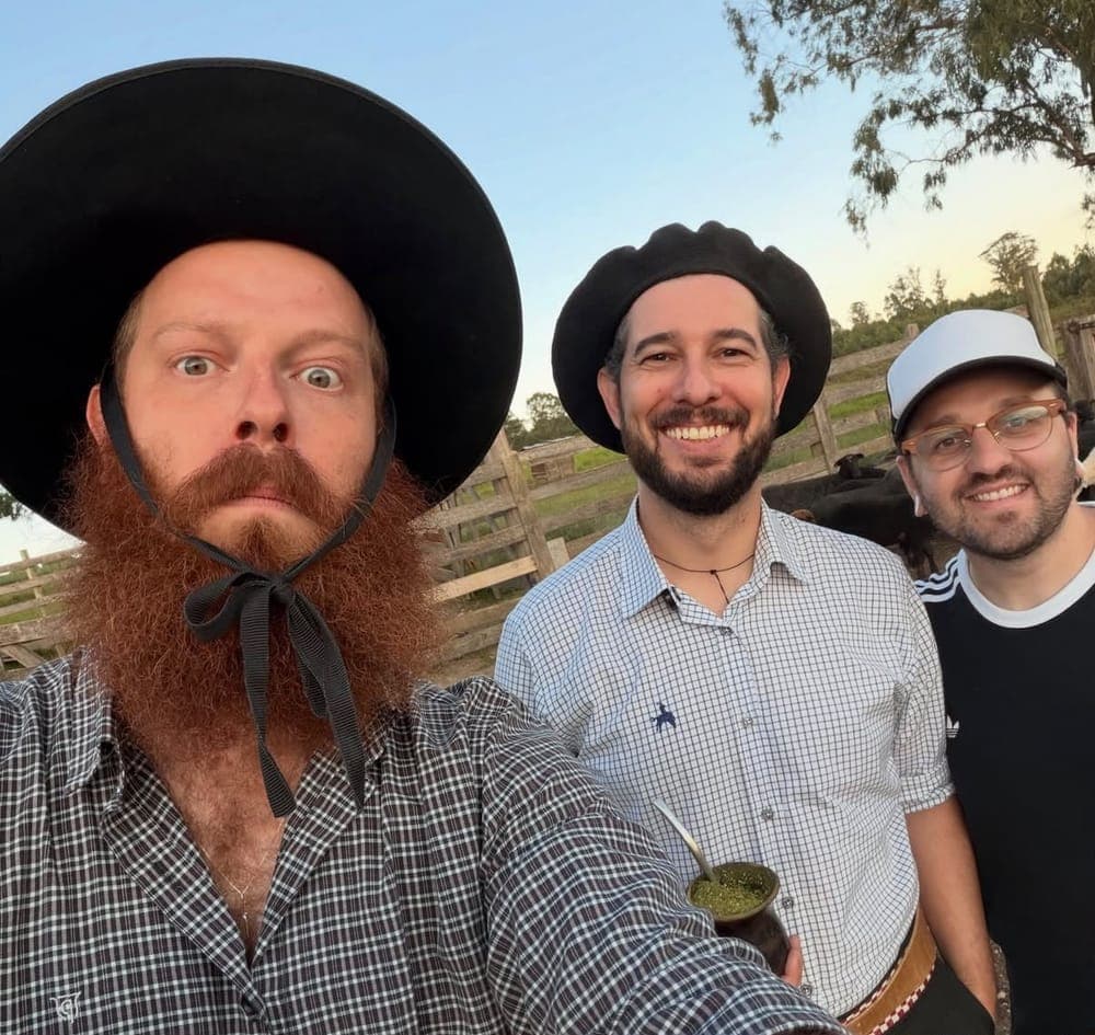 Mateus Rosa com dois artistas tomando chimarrão em uma mangueira